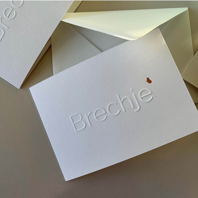 Minimalistisch geboortekaartje met reliëfdruk en goudfolie vlinder