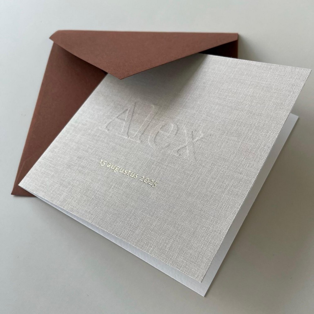 Gevouwen linnen geboortekaartje met subtiele reliëfdruk