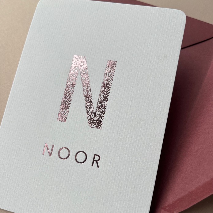 Sereen geboortekaartje met grote letter van gouden bloemen