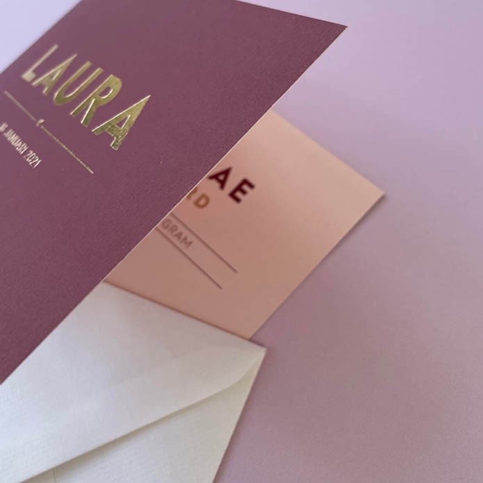 Dubbel gevouwen geboortekaart met strakke letters van goud