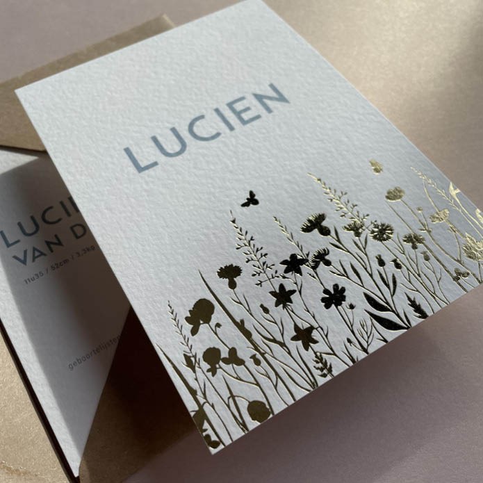 Sereen geboortekaartje met bloemenveld in goudfolie