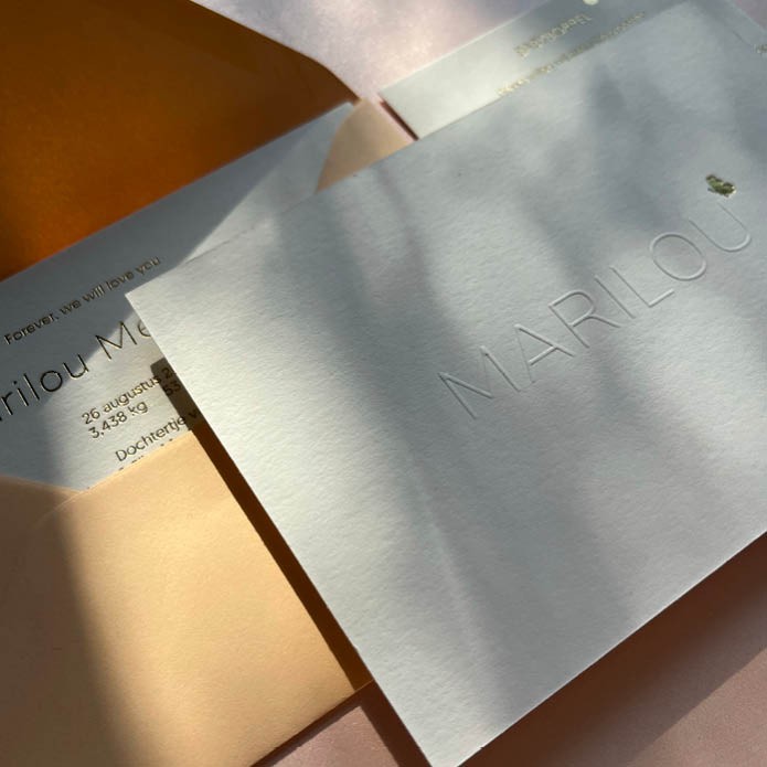 Minimalistisch geboortekaartje met de naam in reliëfdruk