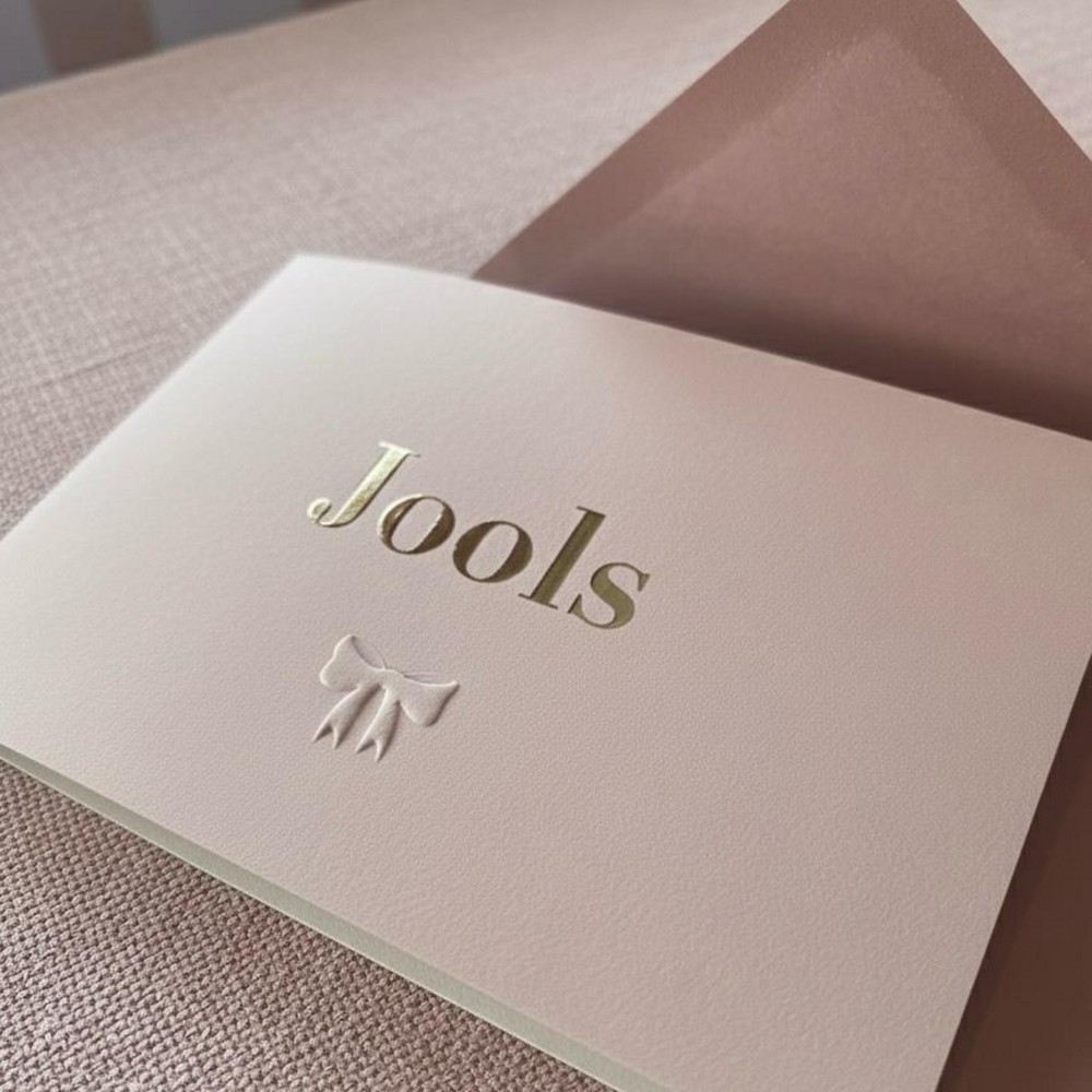 Minimalistisch geboortekaartje met foliedruk en strikje reliëf