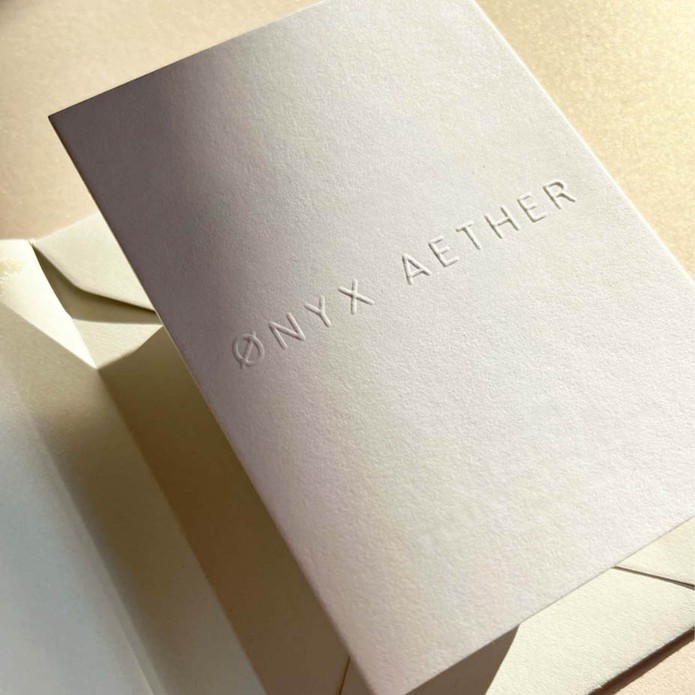 Sober wit geboortekaartje met naam in reliëfdruk unisex