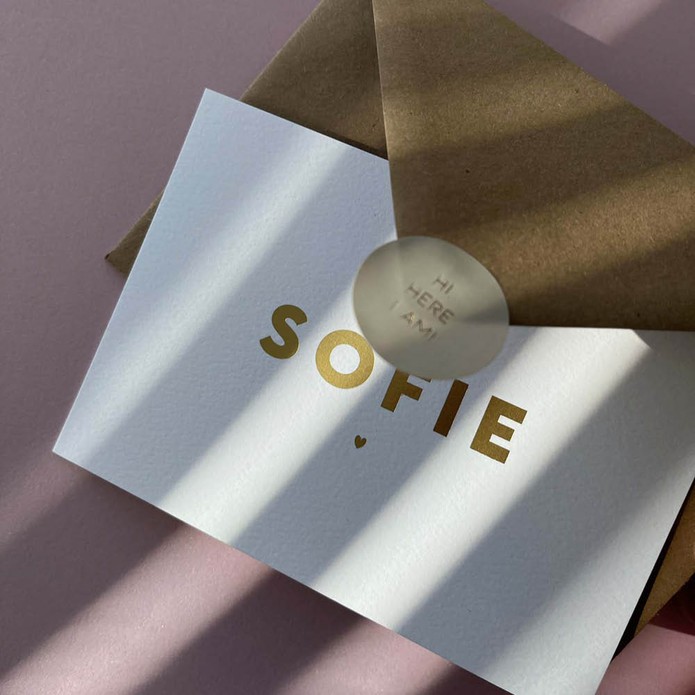 Sober en clean, wit geboortekaartje met eenvoudige naam en hartje in goudfolie