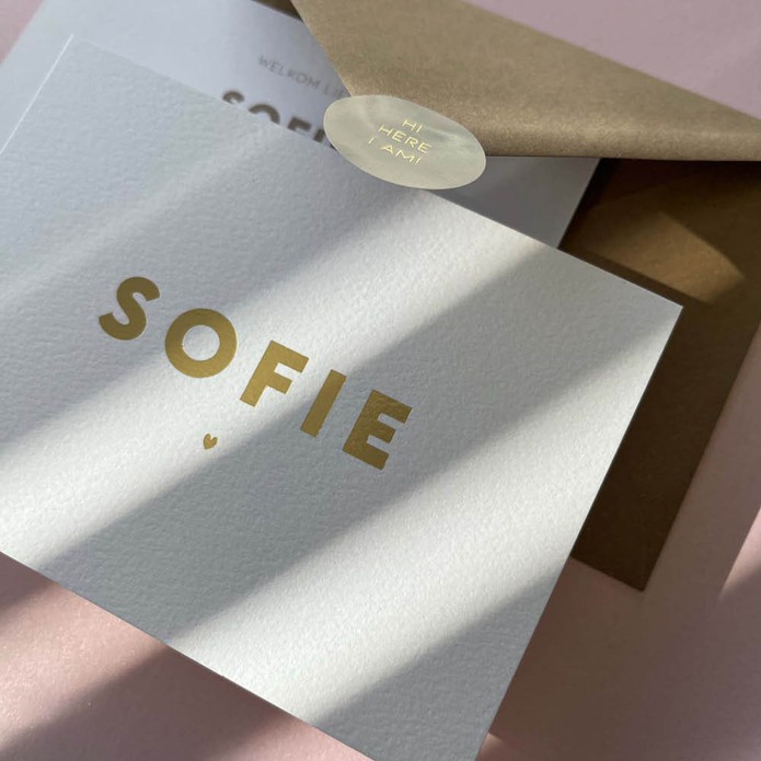 Sober en clean, wit geboortekaartje met eenvoudige naam en hartje in goudfolie